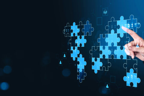 Hand,Placing,Puzzle,Pieces,Forming,A,Glowing,Digital,World,Map,
